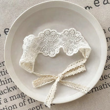 White floral lace baby headband displayed on a light background.