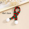 A set of mini knit Christmas hats and scarves in red and green with white pom-poms.