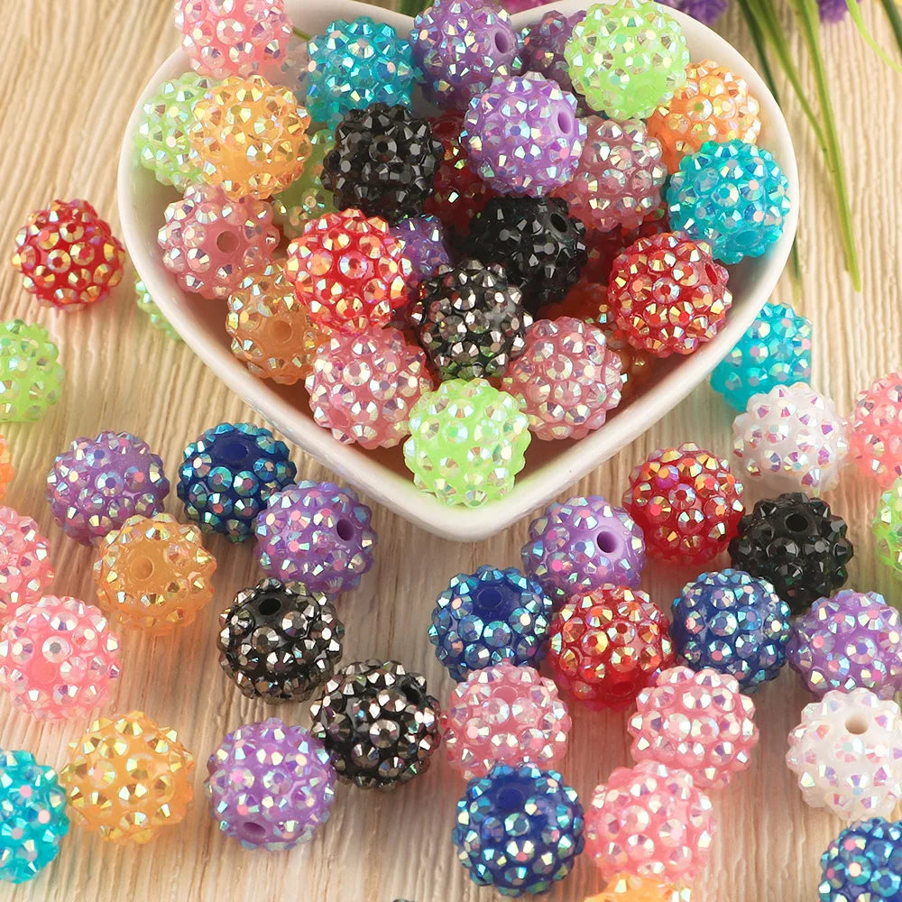 A collection of colorful rhinestone resin bayberry beads in various shades and sizes for jewelry making.