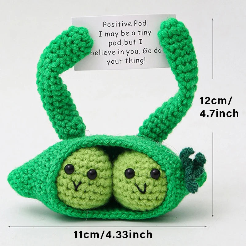 Handmade crochet green alien with a pocket and a sign encouraging confidence