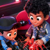 A young child is playing with a red spider-like toy car and black spiders on a black surface.
