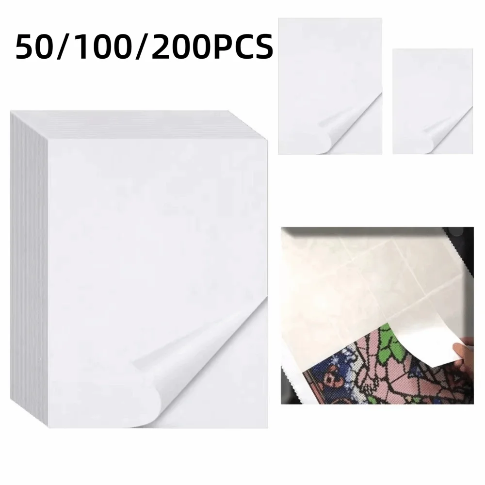 Stack of white double-sided diamond painting release paper sheets and individual sheets.
