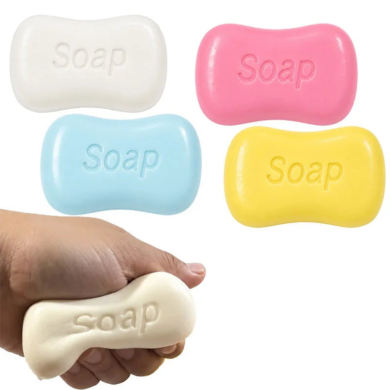 Various soap-shaped squishy stress relief toys in white, pink, blue, and yellow colors held in a hand.