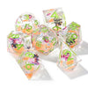 A set of seven pink floral butterfly resin polyhedral dice for tabletop role-playing games