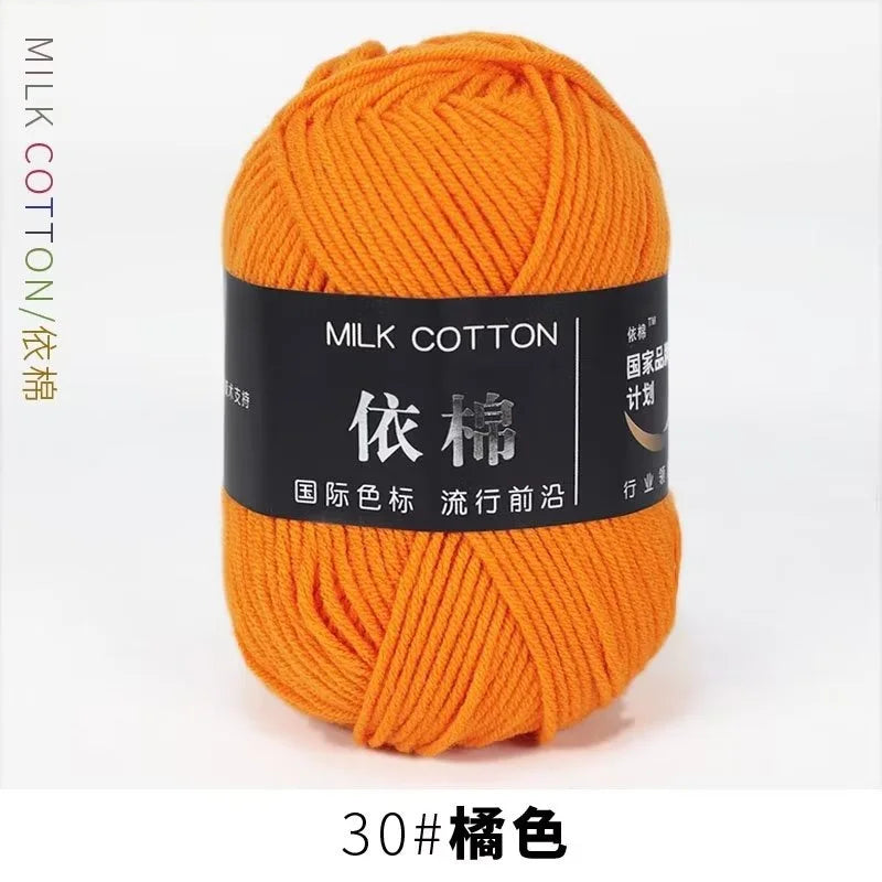 A ball of bright orange milk cotton yarn labeled with Chinese characters for knitting and crochet