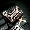 A close-up of a bronze metal magnetic fidget slider placed on a black electronic device.