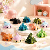 A set of eight colorful flexible salamander figurines in various shades of blue, green, and orange displayed on a light surfa