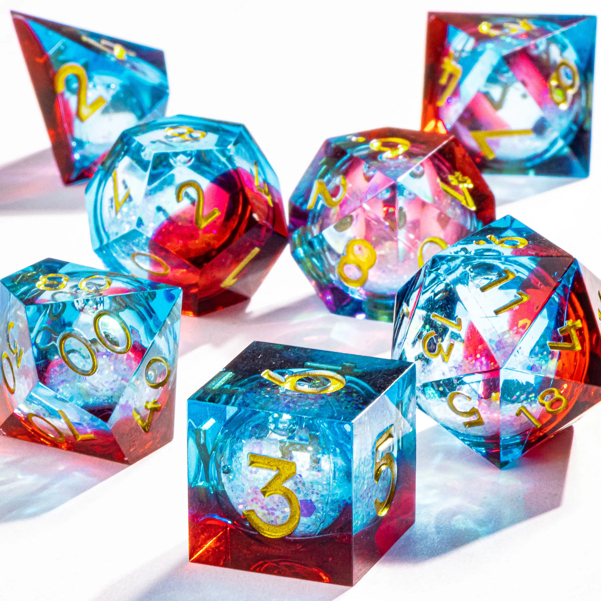 A collection of handmade polyhedral dice featuring a vibrant galaxy finish in blue, red, and purple.