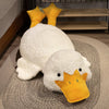 A white plush duck pillow with an orange beak resting on a gray rug.