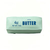 A light green butter squishy stress relief toy labeled 4oz salted butter.