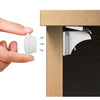 A hand is shown inserting a magnetic cabinet door lock into a wooden cabinet door for child safety.