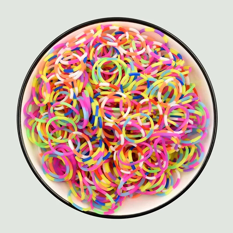A bowl filled with numerous colorful rainbow loom bands for DIY bracelet making.