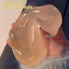 A translucent, pale yellow coconut oil handmade ball is being held by a hand.