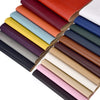 A stack of self-adhesive PU leather repair patches in various colors, arranged diagonally.