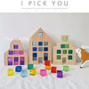 A collection of colorful acrylic building blocks in various shades of purple, blue, green, and yellow arranged on a white sur