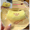 A yellow banana bear squishy stress relief toy is shown on a clear plastic tray.