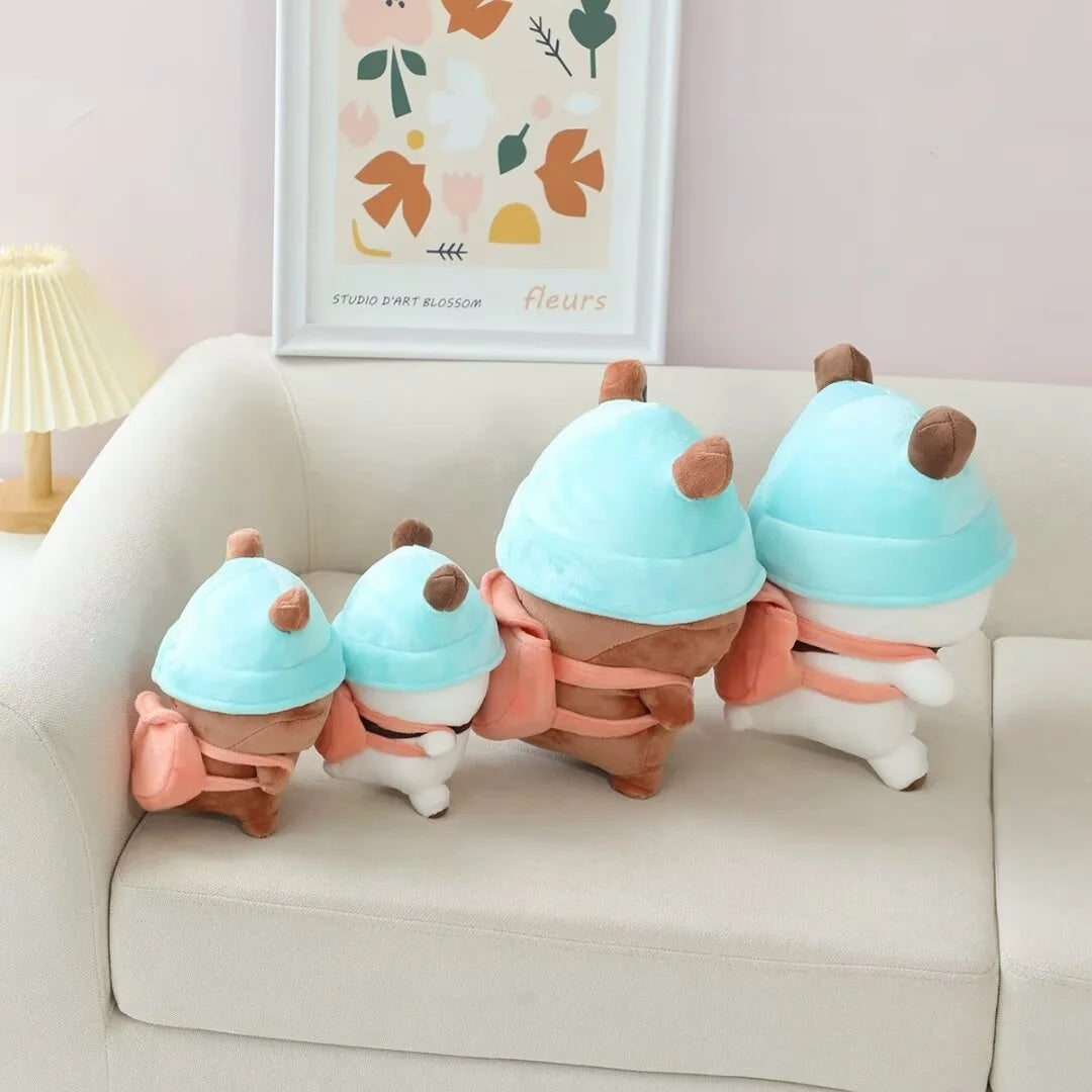 Three adorable light blue and pink panda bear plush toys sitting on a white sofa.