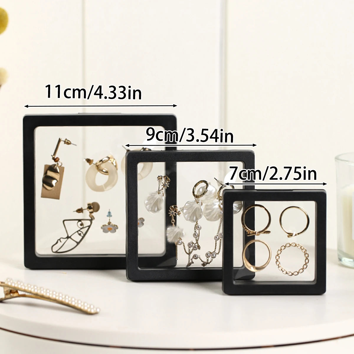 Two black acrylic display boxes showing various gold and silver jewelry pieces.