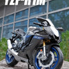 A black Yamaha YZF-R1M diecast motorcycle model is shown outdoors on a rock.