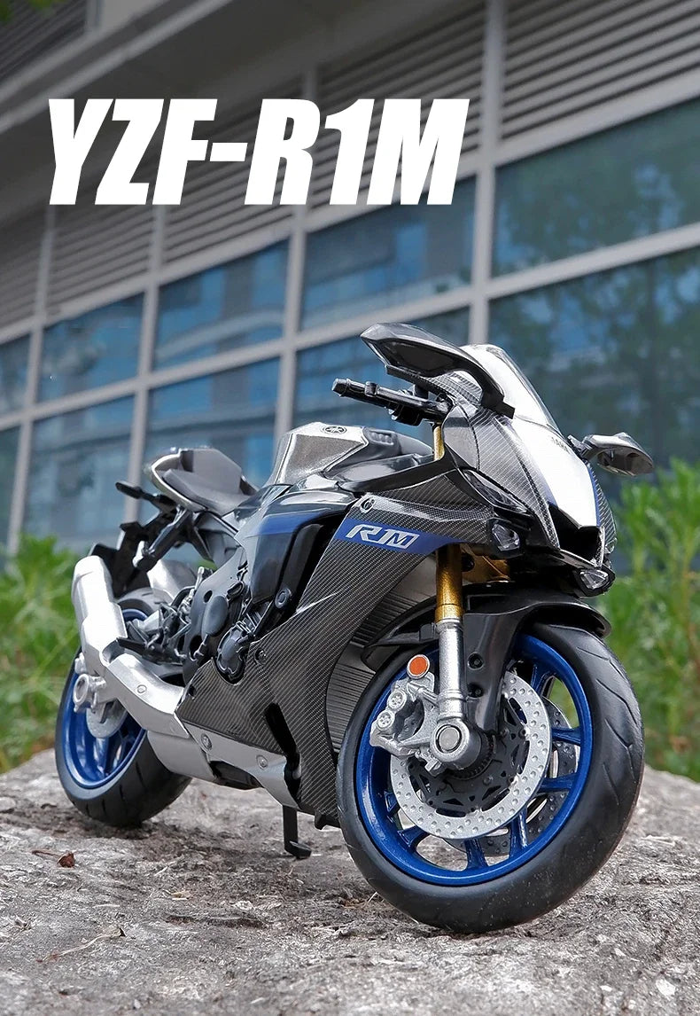A black Yamaha YZF-R1M diecast motorcycle model is shown outdoors on a rock.