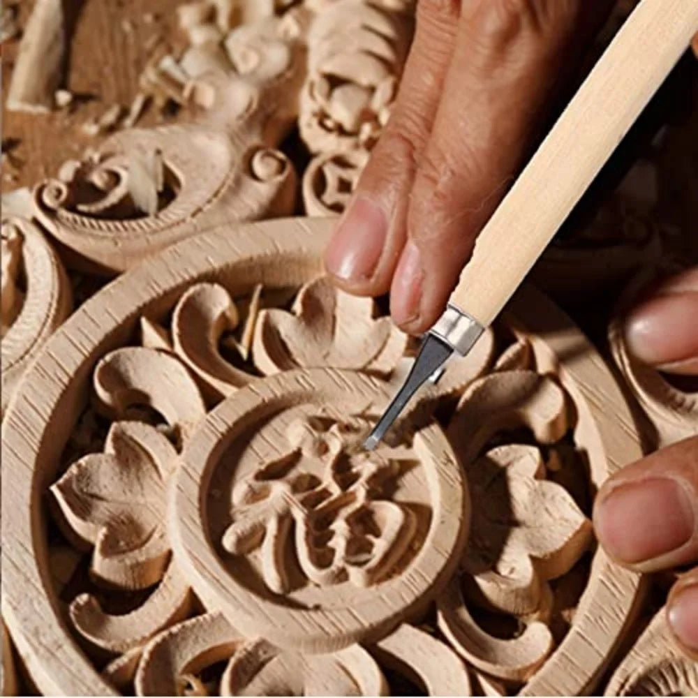 A hand uses a wood carving chisel to shape a detailed floral design in a wooden carving set.