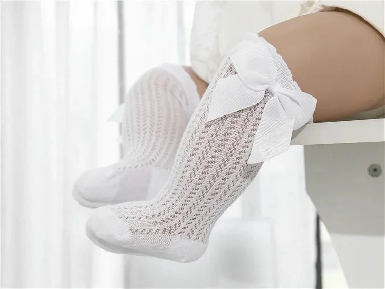 White lace knee socks for a baby girl with a decorative bow