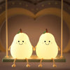 A pair of glowing pear-shaped night lights hanging from a fixture.
