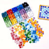 A collection of colorful mosaic glass tiles in various shades arranged in a tray and scattered on a white background.