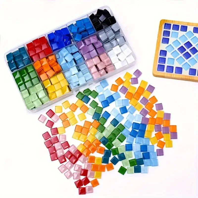 A collection of 300 mosaic tiles in various shades of blue, green, purple, and orange arranged in a tray and loose.