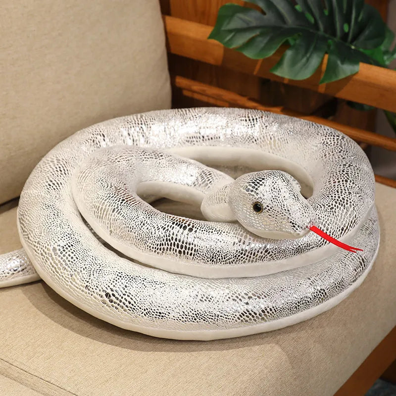 A realistic white giant snake plush toy coiled on a light-colored surface.