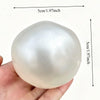 A smooth, translucent white stress ball shaped like an egg, being held in a hand.