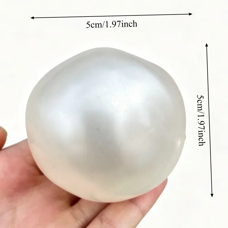A smooth, translucent white stress ball shaped like an egg, being held in a hand.