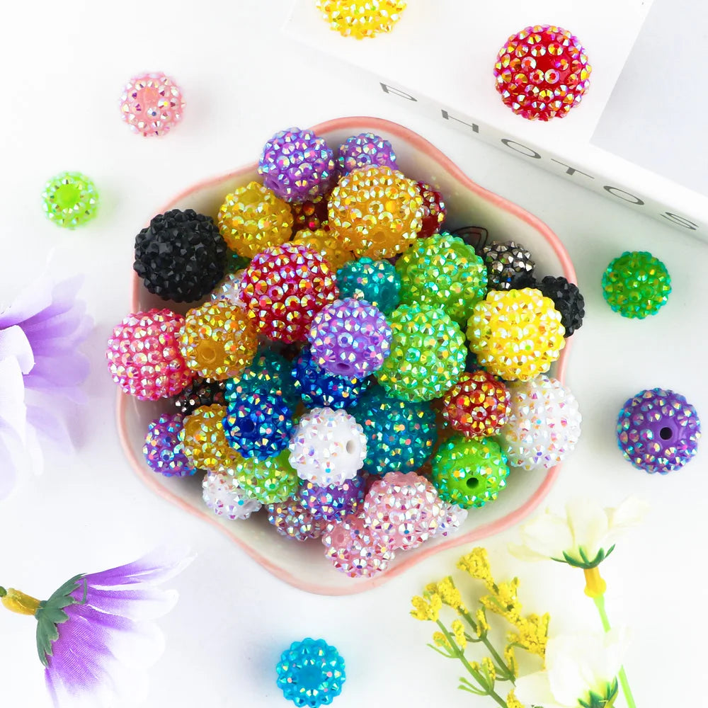 A colorful assortment of glittery rhinestone resin bayberry beads in various shades of purple, green, yellow, and black arran