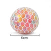 A spherical squishy stress relief ball with a translucent, multicolored, honeycomb-like texture.