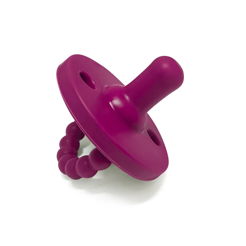 Succionador de silicona para bebé morado con tapa redondeada y base texturizada.