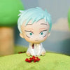 A light blue anime-style figure with spiky hair and large eyes sits on green textured surface.
