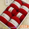 A box of red wool yarn skeins for knitting, showing various colors and textures.
