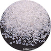 A pile of clear, round Czech glass seed beads for jewelry making.