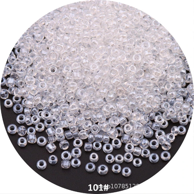 A pile of clear, round Czech glass seed beads for jewelry making.