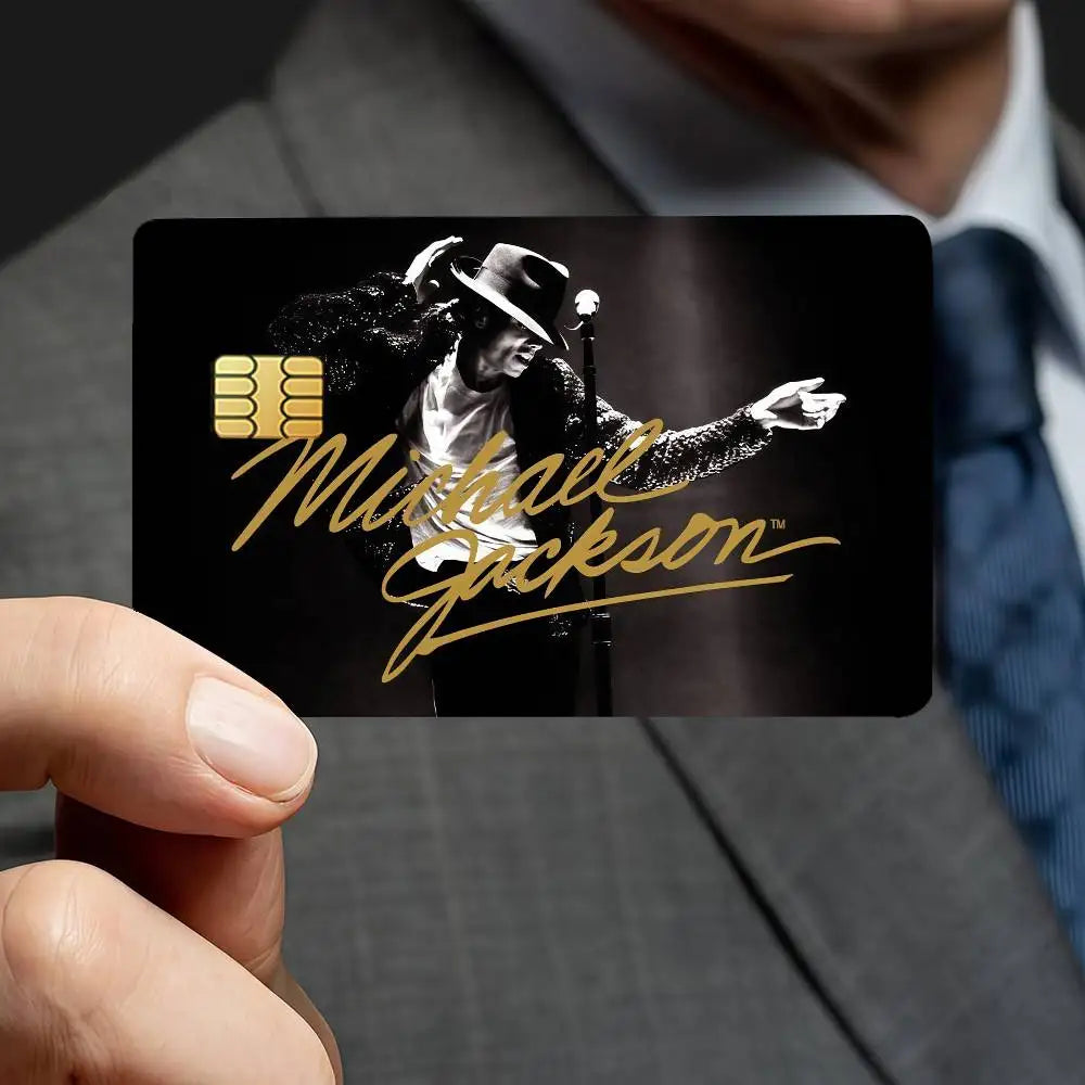 A close-up of a hand holding a black card featuring a silhouette of Michael Jackson and gold text.