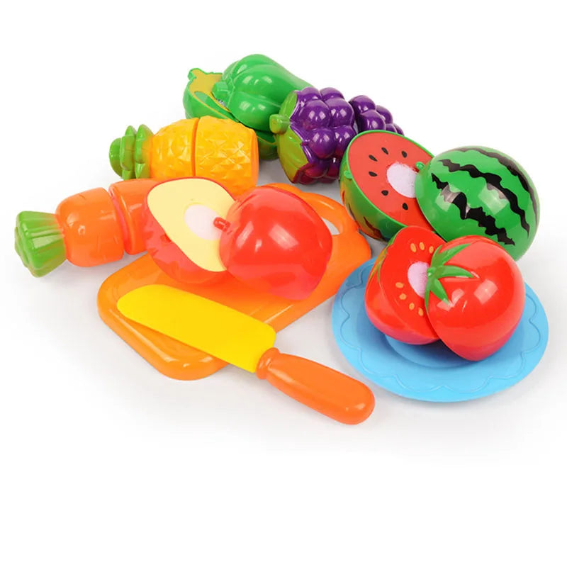 A colorful pretend play kitchen set featuring plastic fruits and vegetables like apples, tomatoes, and cucumbers.