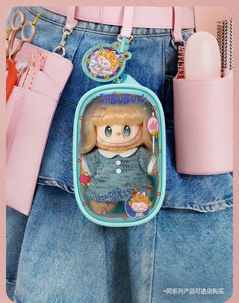 A pink LABUBU doll bag pendant keychain featuring a character with blonde hair and a blue outfit attached to a denim shirt.