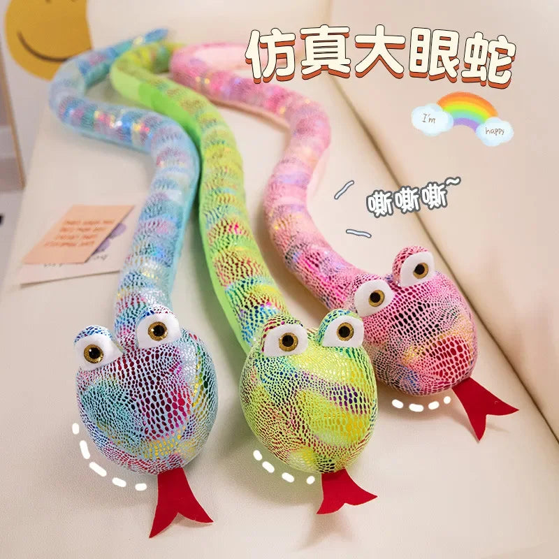 A colorful, long plush toy shaped like a cartoon snake with large eyes and red feet.