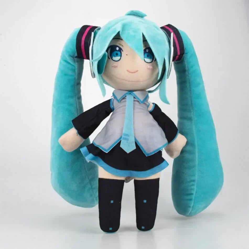 A cute plush doll of Hatsune Miku with light blue hair and large blue eyes, wearing a gray top and blue accents.