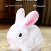A white rabbit plush toy with pink inner ears sitting on a textured surface.