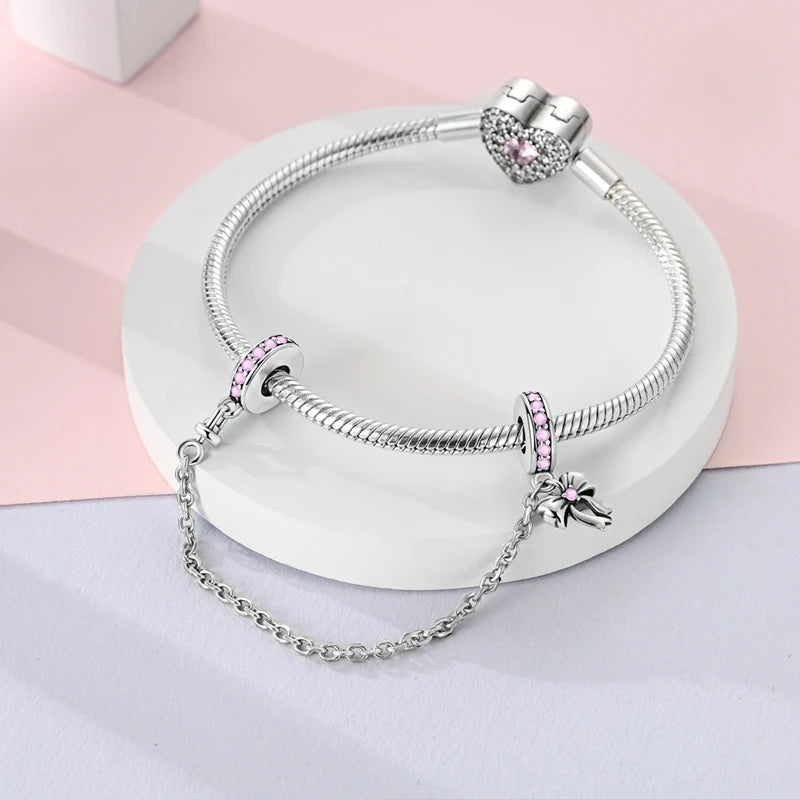 Sterling silver heart charm beads for bracelets featuring pink stones displayed on a white background.