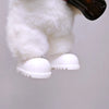 A white fluffy doll outfit featuring a white bear hoodie and white shoes, with a black object visible above.