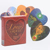 A box of Lovers Oracle Tarot cards and guidebook featuring heart-shaped cards with figures and celestial designs.