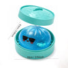 A blue glitter shark dumpling squishy fidget toy with a matching teal steamer box.