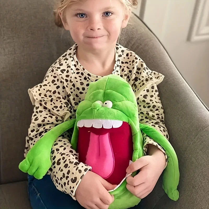 A young girl is holding a green ghost plush toy with a large pink mouth and green arms.
